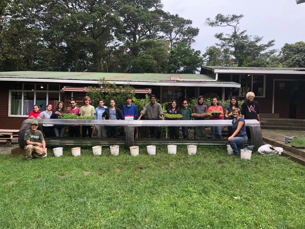 Students, visitors, and guests pose in front of a greenhouse donated through our greenhouse donation program. 