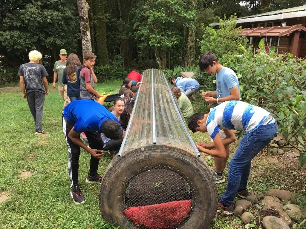 Young people explore our greenhouses that are donated to schools and classrooms to learn about permaculture and regenerative practices.